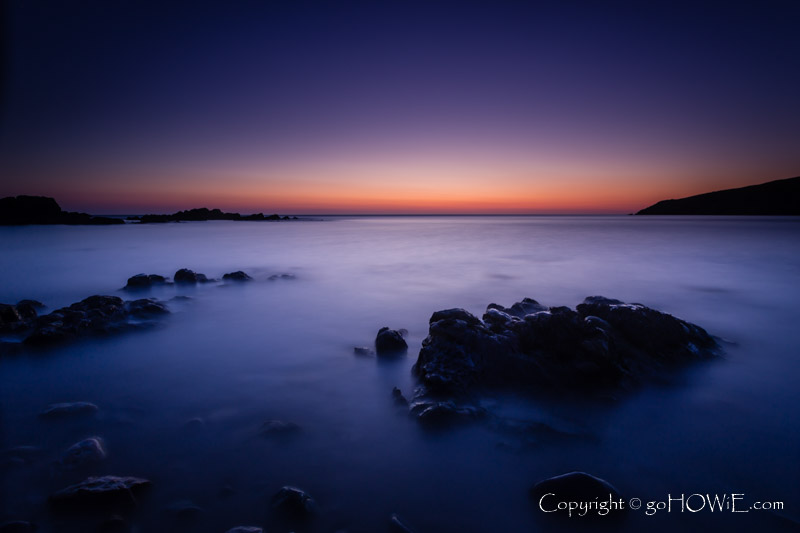 The beach at Church Bay, Anglesey, at dusk with rocks and sea