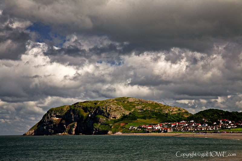 Photo of the Little Orme taken from the East Shore promenade at Llandudno on the North Wales coast with cumulus clouds overhead