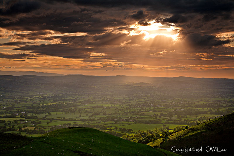 The sun shining through clouds over the Vale of Clwyd, North Wales