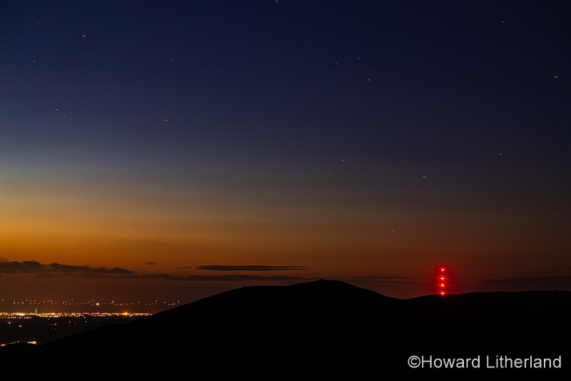 Clwydian range hills at night with stars and Moel-y-Parc transmitter mast