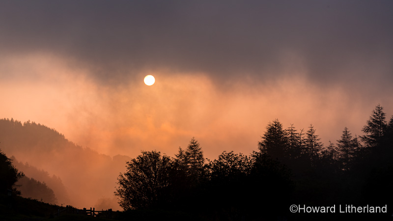 Sunrise through fog over the Clwydian Range, North Wales
