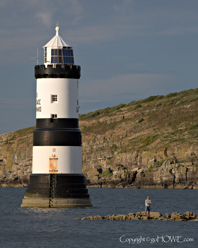 Penmon lighthouse with an angler to give a sense of scale, Anglesey, North Wales