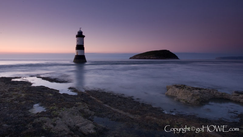 Penmon lighthouse at dusk, with Puffin Island in the background, Anglesey, North Wales