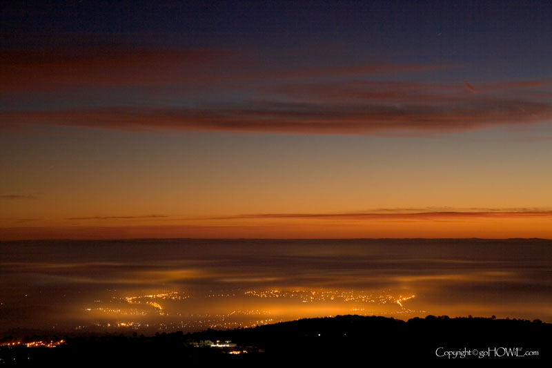 Streetlights shining through a layer of mist at dawn. View is to the east from the top of Moel Famau
