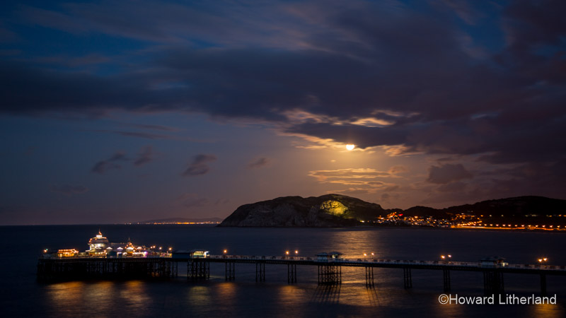 Llandudno Pier and the Little Orme at night under a full moon, North Wales