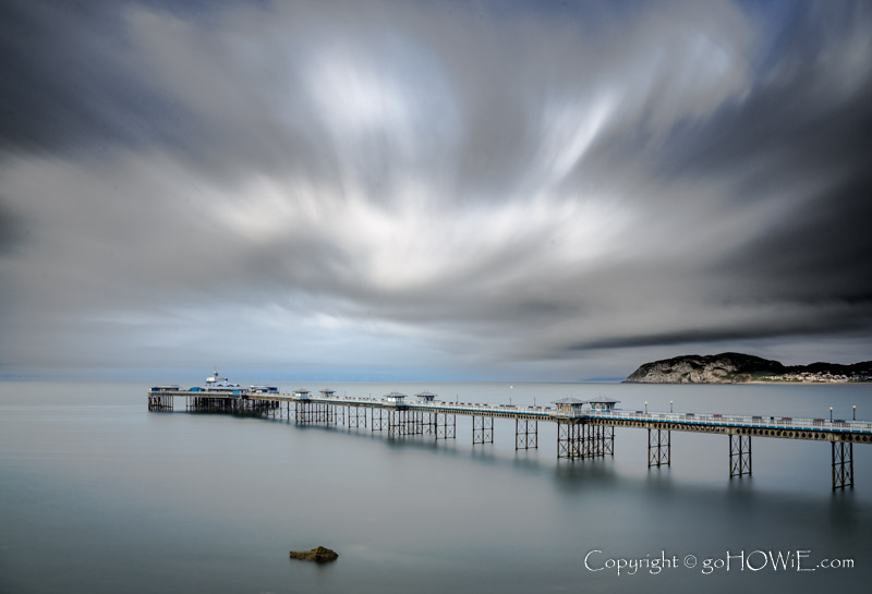Llandudno pier and the Little Orme under dramatic clouds on the North Wales coast
