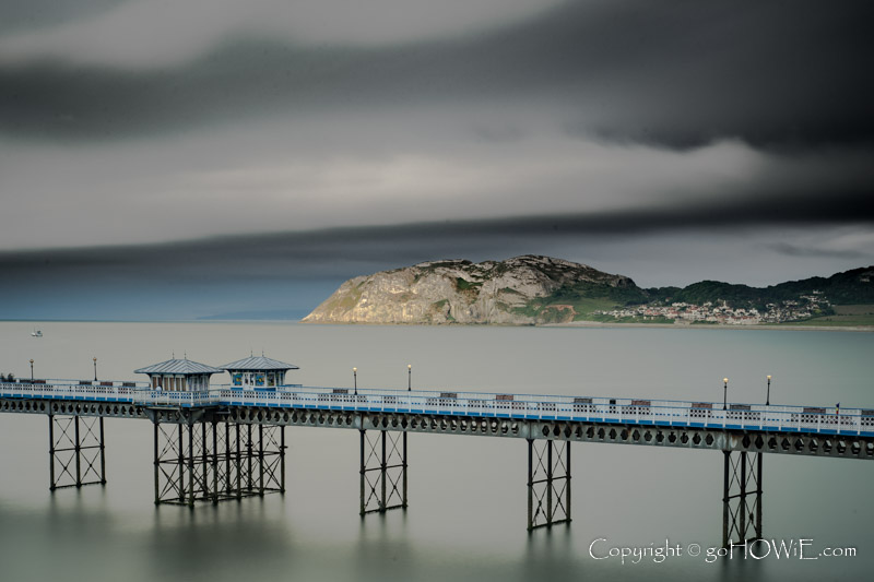 Llandudno pier and the Little Orme under dramatic clouds on the North Wales coast