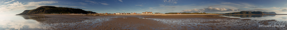 Panoramic image of the seafront at Llandudno West Shore, looking towards the shore from out on the beach