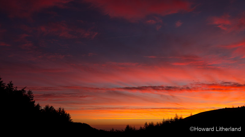 Clouds catching the colourful light of the rising sun at Moel Famau, North Wales