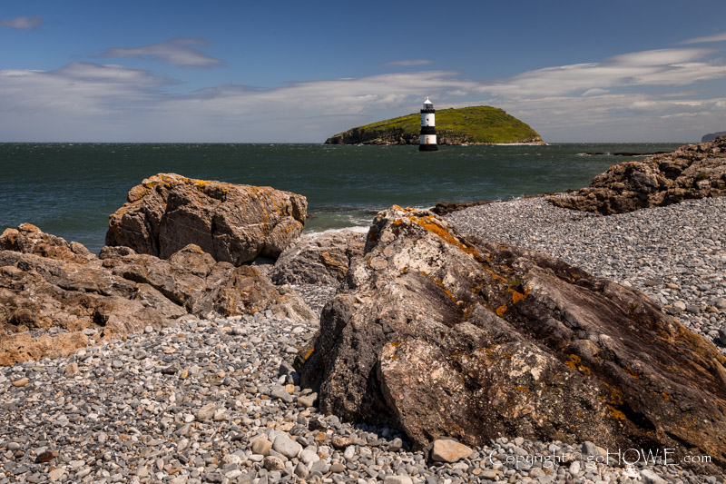 Penmon lighthouse and Puffin Island with rocky foreshore, Anglesey, North Wales