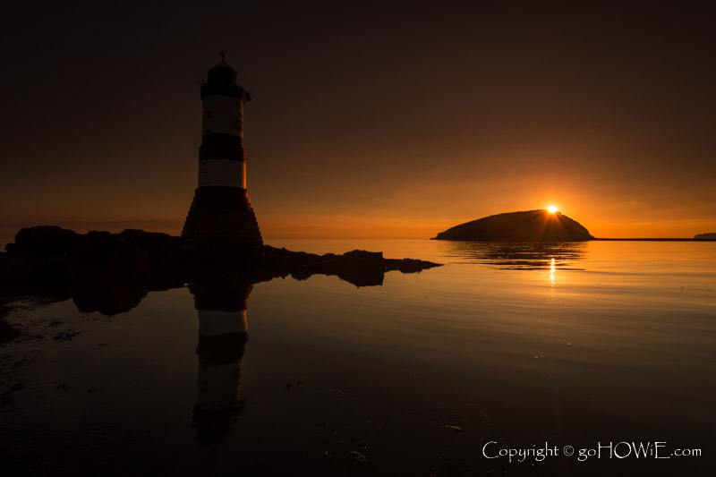 Penmon lighthouse and Puffin Island at sunrise on a still morning, Anglesey, North Wales