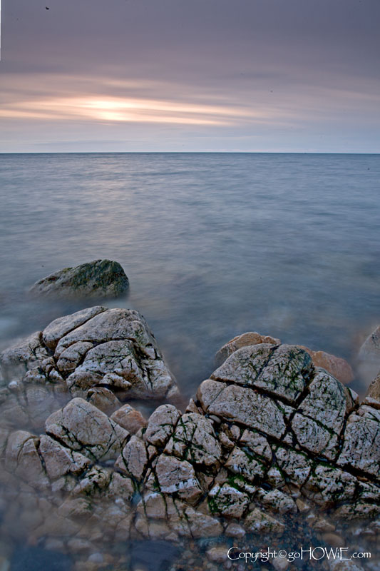 Rock surrounded by sea at sunset, Church Bay, Anglesey, North Wales