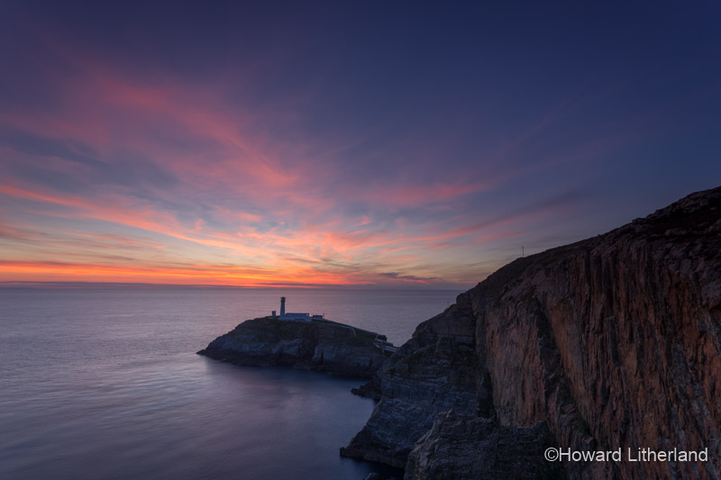 Lighthouse and cliffs at South Stack at dusk on the Isle of Anglesey, North Wales