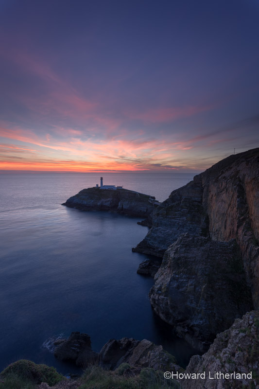 Lighthouse and cliffs at South Stack at dusk on the Isle of Anglesey, North Wales