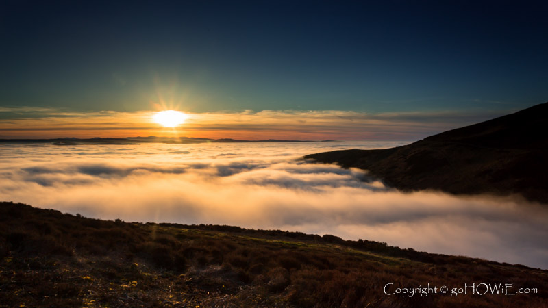 Sun setting over a bank of fog in the Vale of Clwyd, North Wales