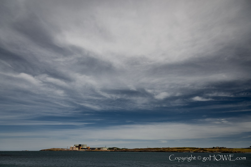 Wylfa nuclear power station on Anglesey, North Wales with dramatic clouds overhead, as seen from the nature reserve at Cemlyn