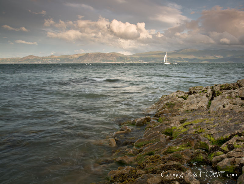 Yacht approaching Penmon Point, Anglesey, North Wales