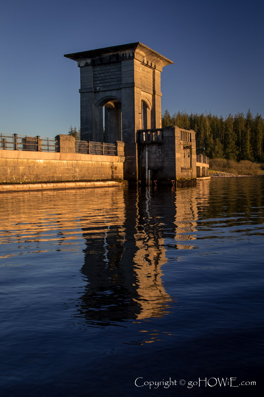 Dam, reflecting in the waters of Alwen Reservoir, North Wales