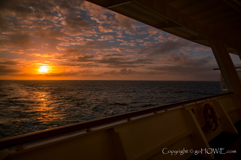 The sun setting into the Atlantic Ocean from the stern of the P&O cruise liner Azura
