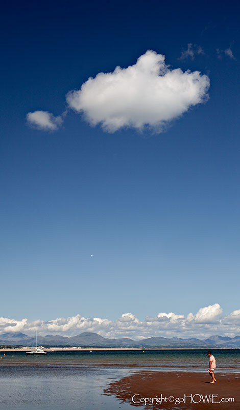 A solitary cumulus cloud over the beach at Llanbedrog on the Llyn Peninsula, Wales