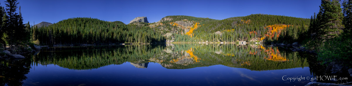 Panoramic image of Bear Lake in the Rocky Mountain National Park, with reflections of Hallett Peak and golden aspen trees, Colorado, U.S.A.