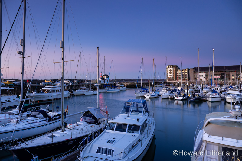 Yachts moored in the Victoria Dock at Caernarfon at dusk on the North Wales coast