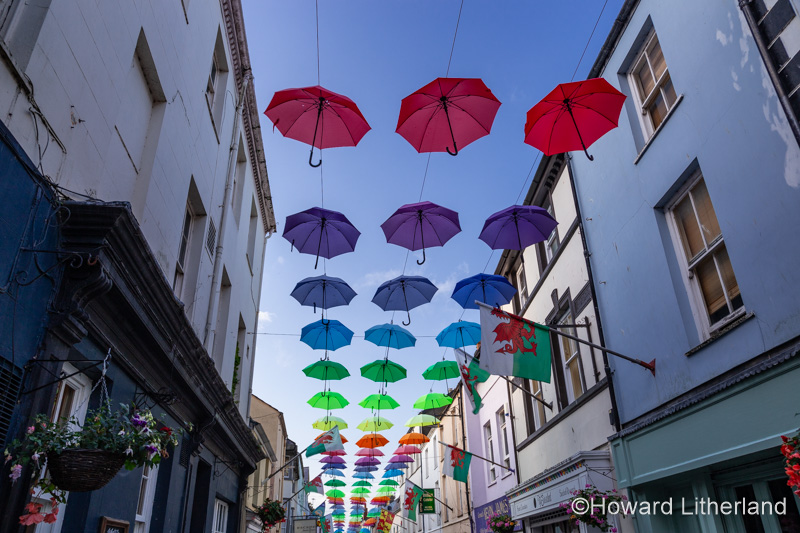 Multi-coloured umbrellas over Palace Street, Caernarfon, North Wales