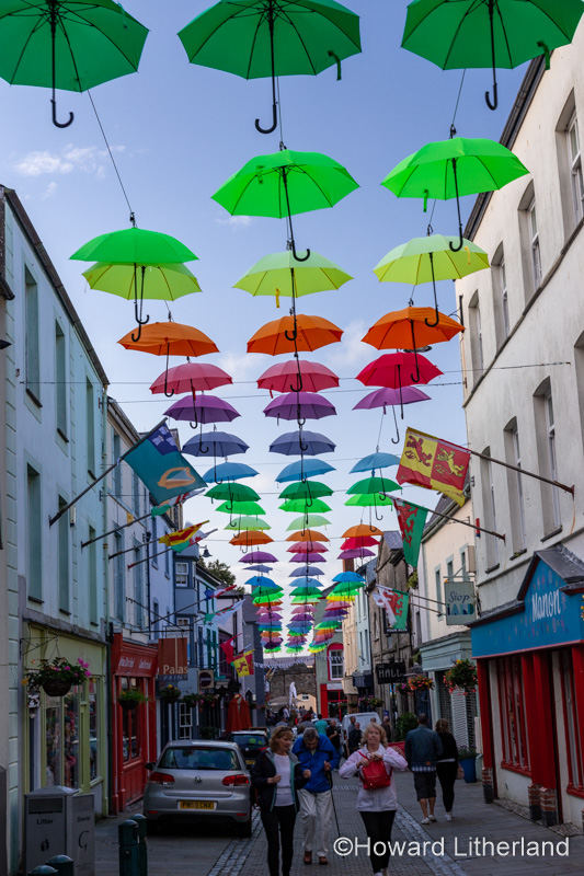 Multi-coloured umbrellas over Palace Street, Caernarfon, North Wales