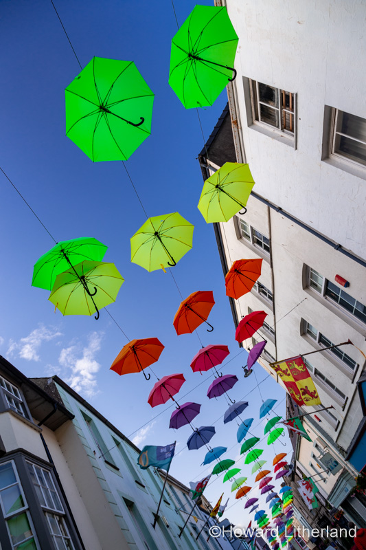 Multi-coloured umbrellas over Palace Street, Caernarfon, North Wales