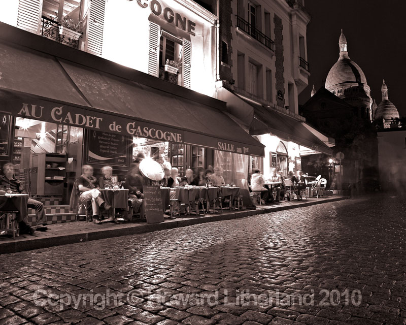 Cafe in the Place du Tetre at night with the Sacre Coeur in the backgound, Paris, France