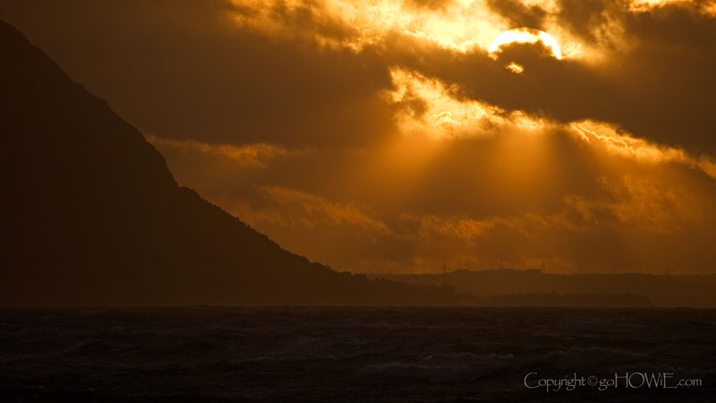 The sun breaking though stormy clouds over the headland of Penmaenmawr on the North Wales coast