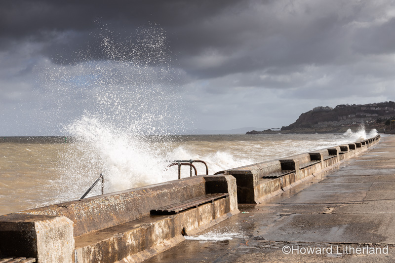 Waves crashing on Colwyn Bay seawall in a storm at high tide on the North Wales coast
