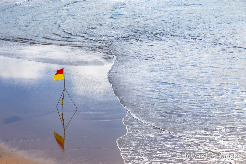 Warning flag on wet sand at Bude on the North Cornwall coast
