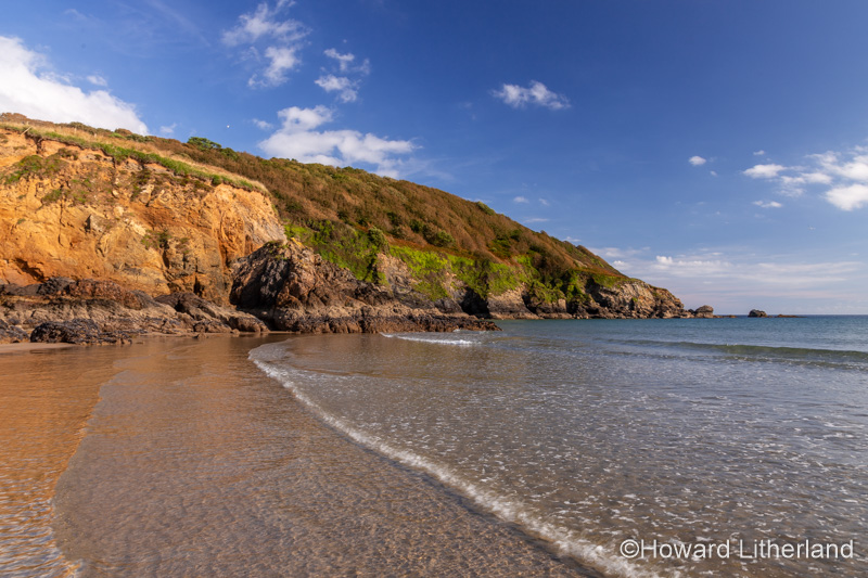 Gentle waves on the beach at Porthluney Bay, South Cornwall, England