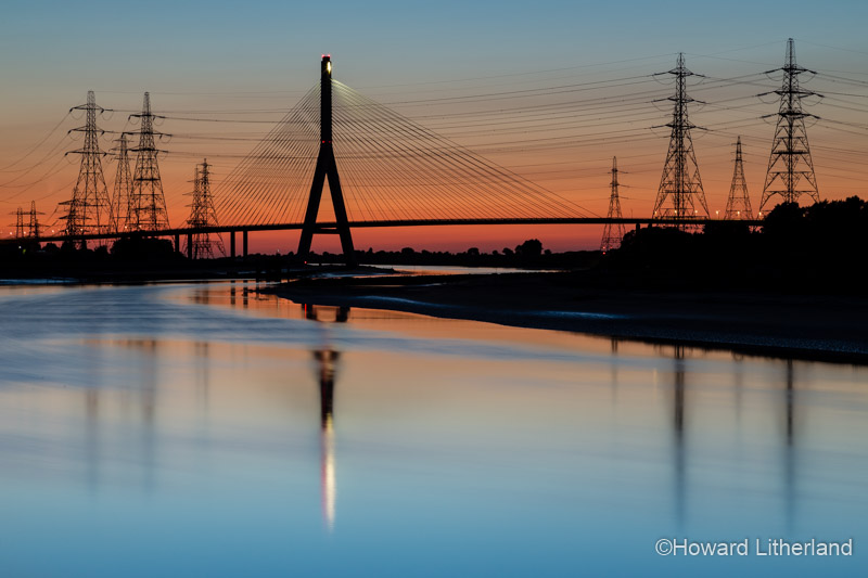 Colourful sky at dusk over the river Dee estuary on the North Wales coast, featuring the Flintshire suspension bridge and Connah's Quay power station