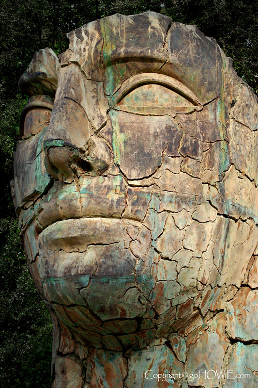 Sculpture of a large bronze cracked head by Polish sculptor Igor Mitoraj in the Boboli Gardens, Florence, Italy