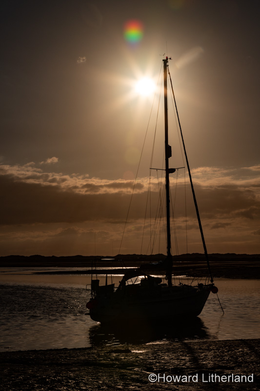 Yacht in silhouette at Ravenglass, Lake District, England