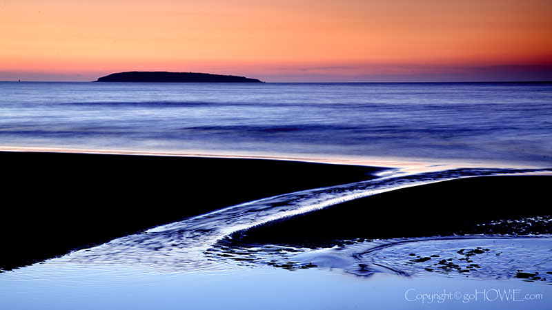 Tidal pool and Puffin Island at dusk from Llanfairfechan beach, Wales