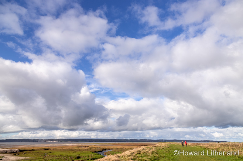 Walkers at Llanfairfechan salt marsh, North Wales coast
