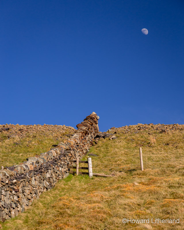Drystone wall and gibbous moon at Marchlyn Mawr in Snowdonia, North Wales