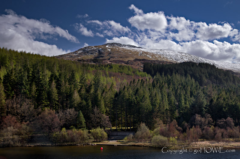 The snow capped peak of Moel Siabod and the forested banks of Llyn Mymbyr, Snowdonia National Park, Wales