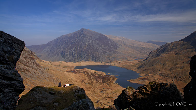 People sunbathing on the Devil's Kitchen, above Llyn Idwal with the mountain Pen Yr Olwen in the background, Snowdonia, North Wales
