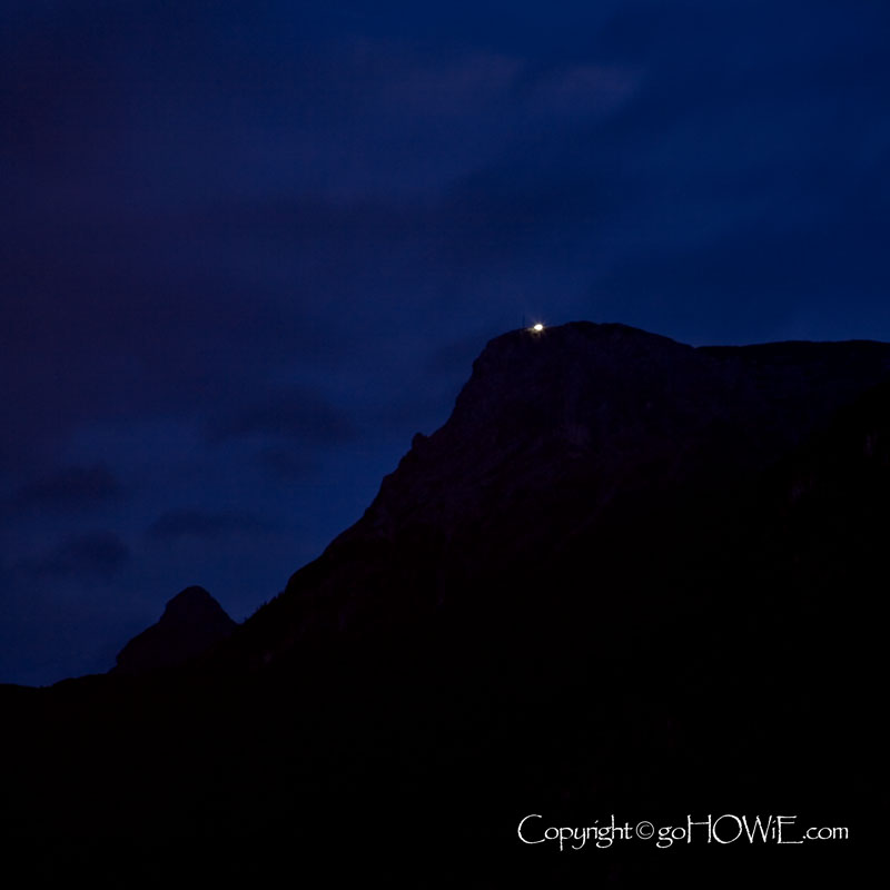 Mountain at night with pinpoint of light, Austria