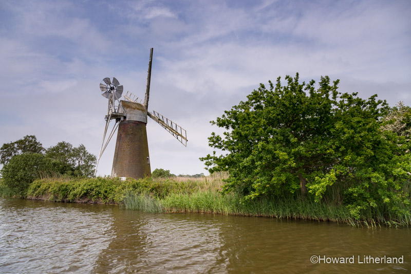 Windmill by a river in the Norfolk Broads, England