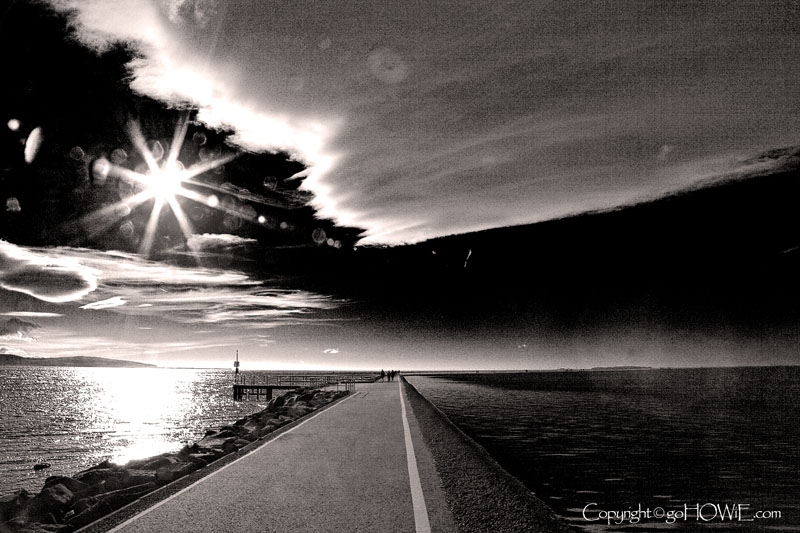 Path around the Marine Lake at West Kirby on the Wirral. The image includes the sun and a triangular cloud