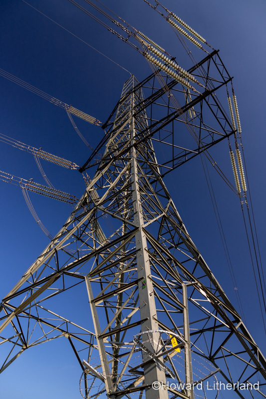 Electricity pylon and cables against a blue sky