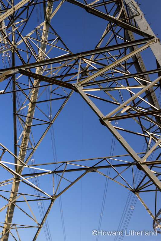 Electricity pylon and cables against a blue sky