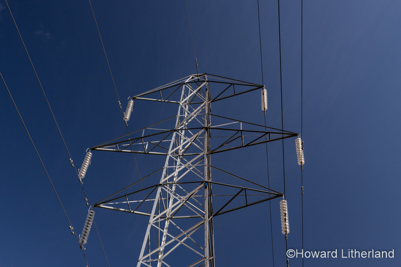 High voltage electricity pylon in sunlight