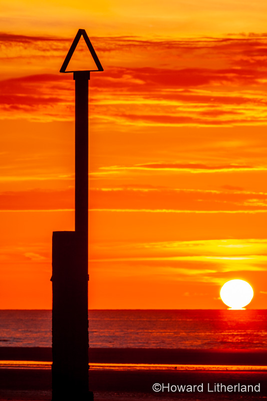 Sunset over Rhyl beach at low tide on the North Wales coast