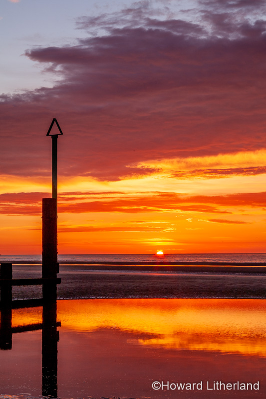 Sunset over Rhyl beach at low tide on the North Wales coast